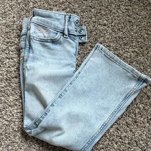 Girls 5/6 bootcut light colored jeans with pink bow detail on pocket